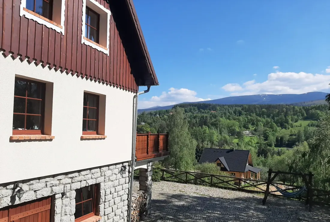 Fasada domu z drewnianym szczytem i kamienną podmurówką